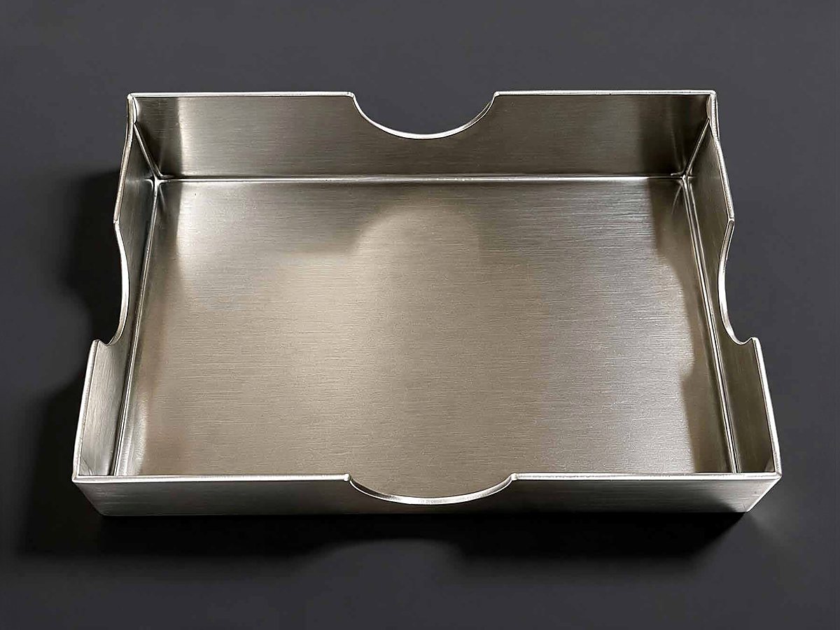 Production jig berupa tray stainless steel untuk menahan dan membentuk susunan produk